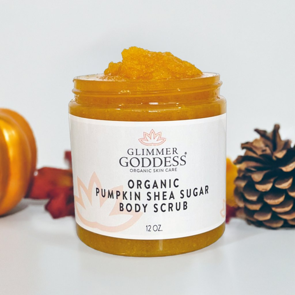 Glimmer Goddess Organic Pumpkin Shea Sugar Body Scrub surrounded by autumn decor, highlighting its pumpkin spice scent and nourishing properties.