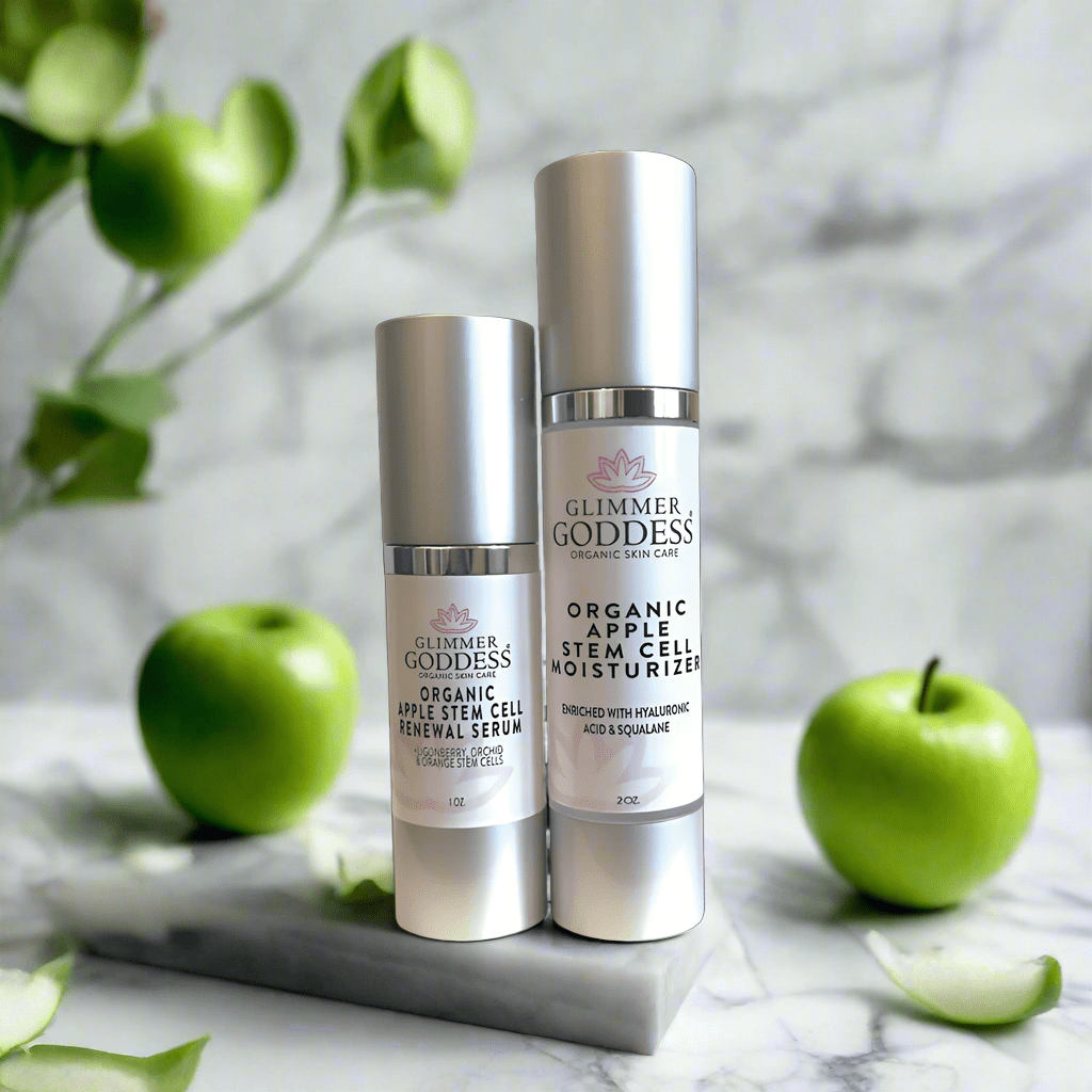 Glimmer Goddess Organic Apple Stem Cell Anti-Aging Duo with green apples in the background, features a nourishing serum and moisturizer for a glowing complexion, by GNS Beauty & Personal Care.