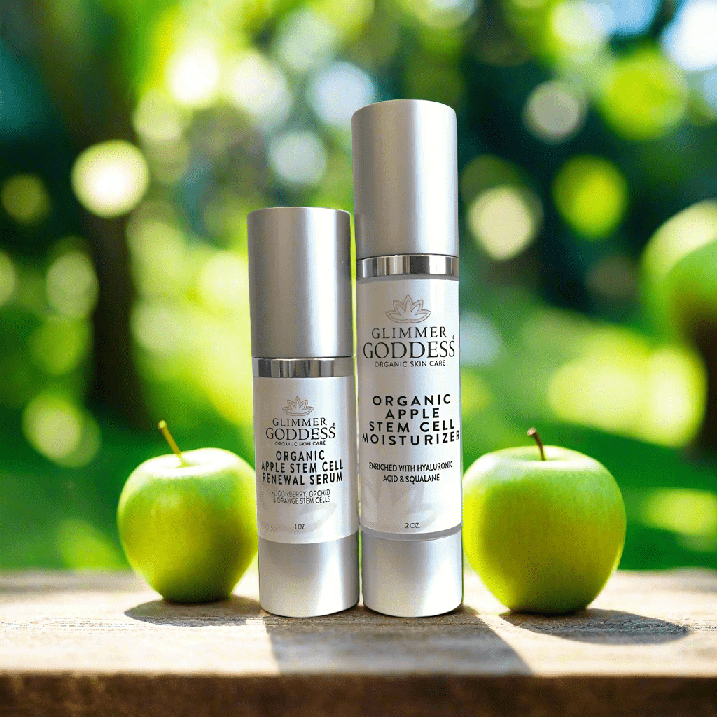 Glimmer Goddess Organic Apple Stem Cell Anti-Aging Duo displayed amidst green apples, showcasing the Renewal Serum and Moisturizer from GNS Beauty & Personal Care.