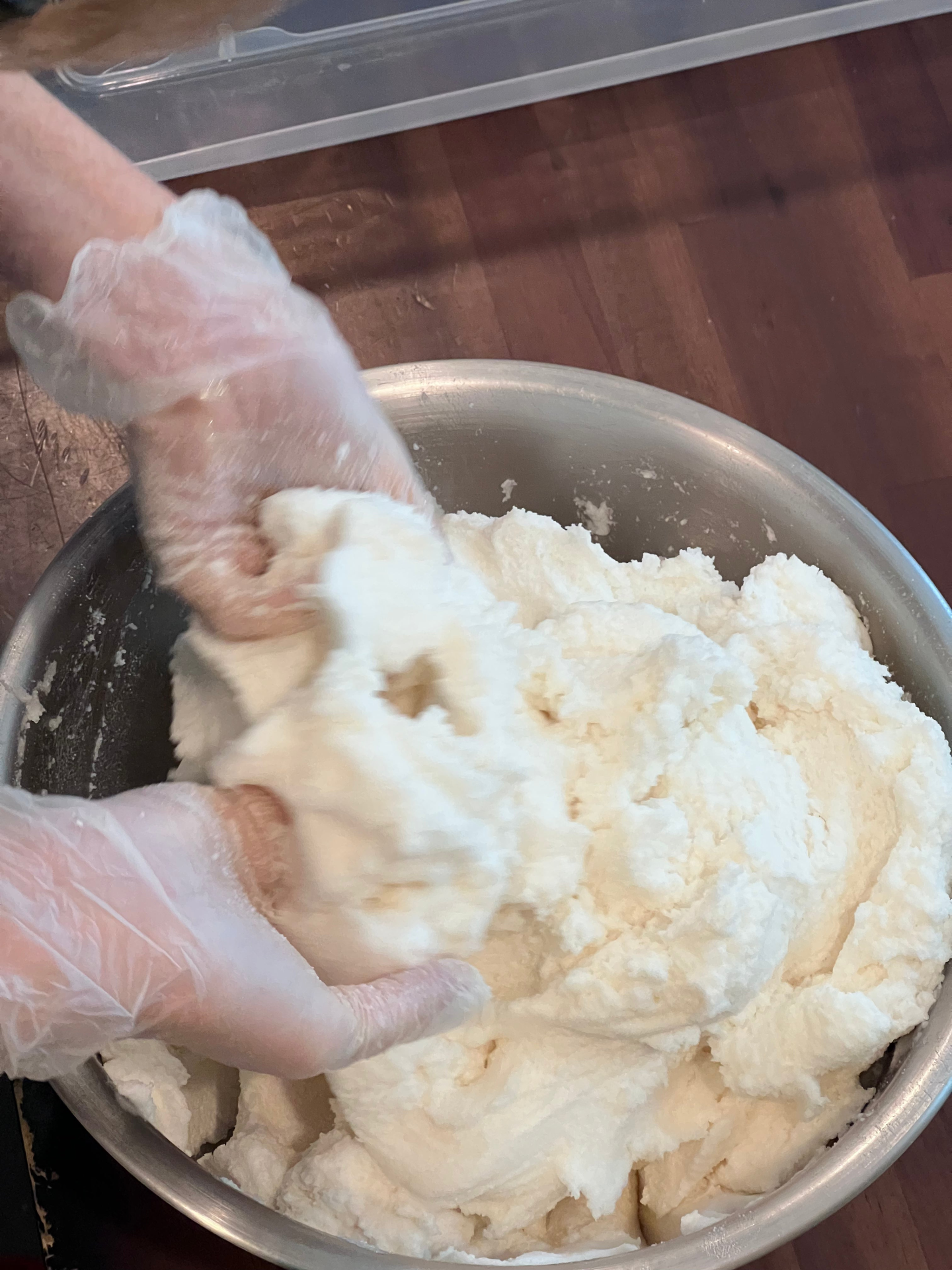 Hands mixing the creamy texture of the Glimmer Goddess Organic Whipped Sugar Fondant Exfoliating Body Scrub, a perfect treatment for crepey skin by GNS Beauty & Personal Care.