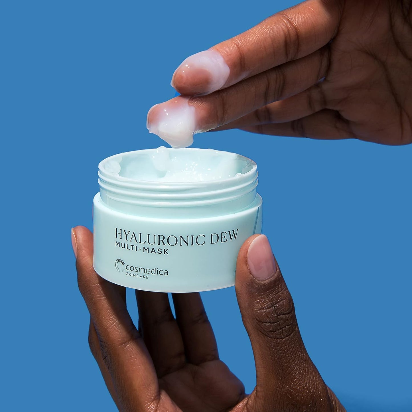 Hyaluronic Dew Multi-Mask from Cosmedica Skincare shown in a hand, highlighting its creamy texture being applied for hydration.