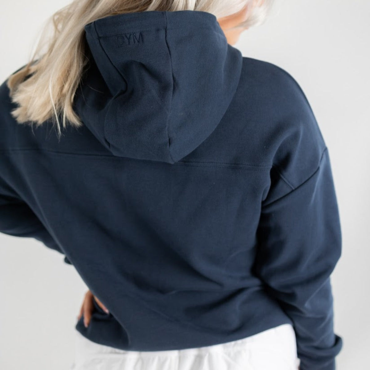 Back view of the Cozy Up Cowl Neck Hoodie by DYM Athletics, highlighting the hoodie’s design and logo, offering comfort and style for any occasion.
