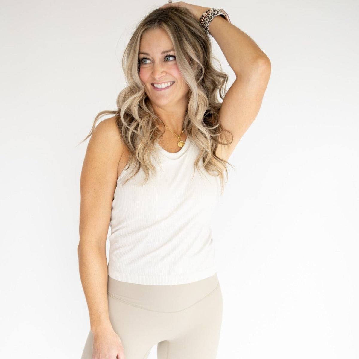 Model wearing the Restore Ribbed Comfort Tank w/ Built in Bra by DYM Athletics, showcasing a stylish and flattering fit in a neutral color, ideal for gym or casual outings.