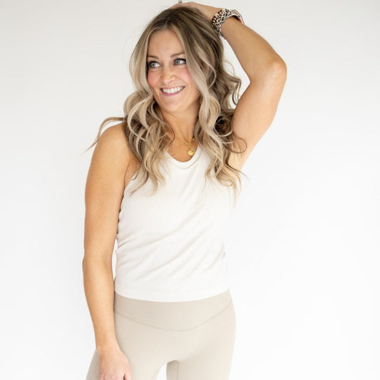 Model wearing the Restore Ribbed Comfort Tank w/ Built in Bra by DYM Athletics, showcasing a stylish and flattering fit in a neutral color, ideal for gym or casual outings.