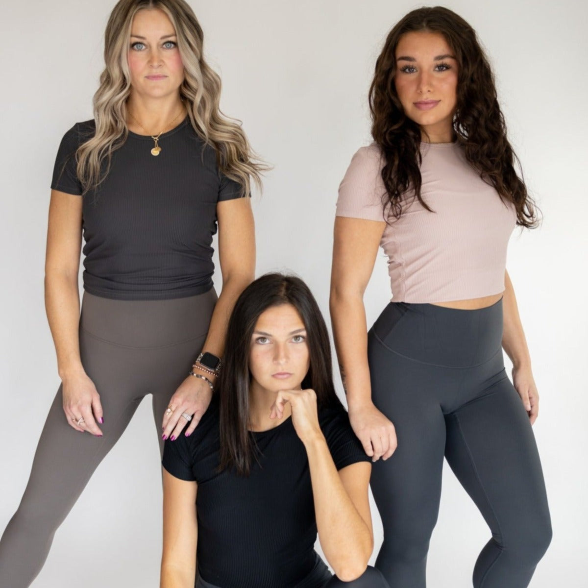 Group of models wearing the Restore Ribbed T-shirt in various colors by DYM Athletics, styled with high-waisted leggings for a trendy look.