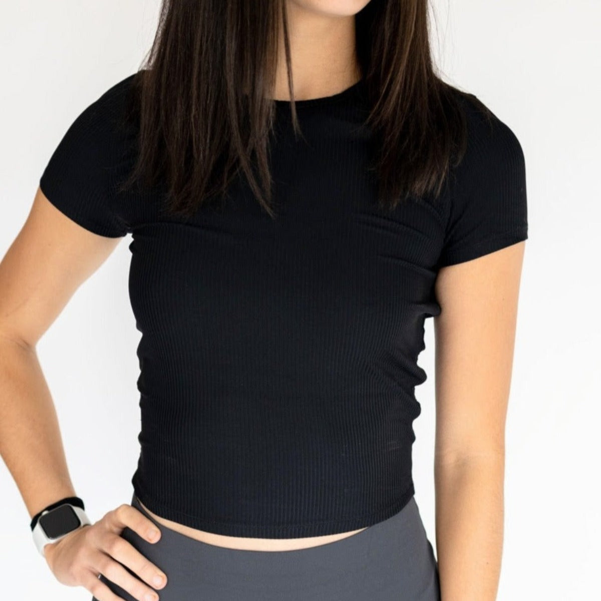 Close-up of a model wearing the black Restore Ribbed T-shirt from DYM Athletics, emphasizing the stylish cropped fit and ribbed fabric.