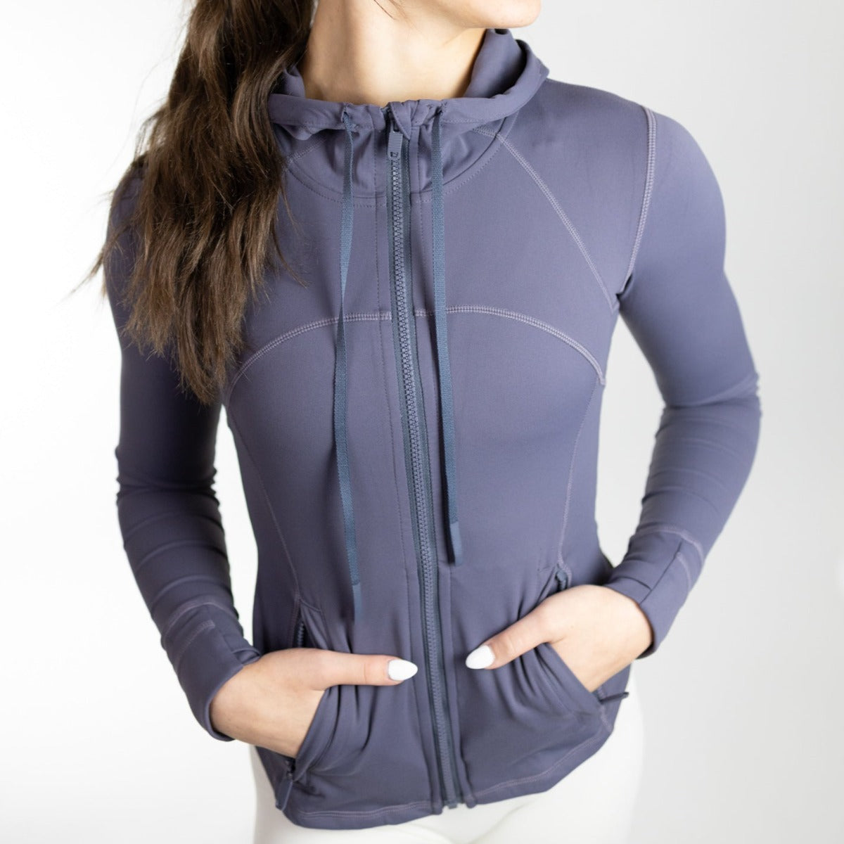 A woman modeling a navy Active Lightweight Hooded Zip Up by DYM Athletics, highlighting its lightweight design ideal for workouts and casual wear.