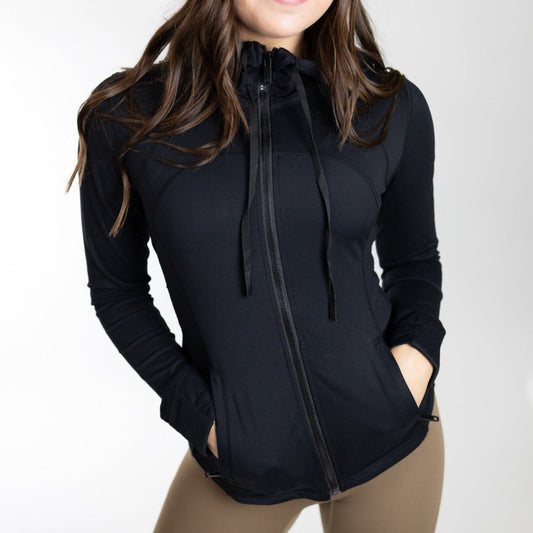 A woman wearing a black Active Lightweight Hooded Zip Up by DYM Athletics, showcasing comfort, breathability, and mobility for workouts.