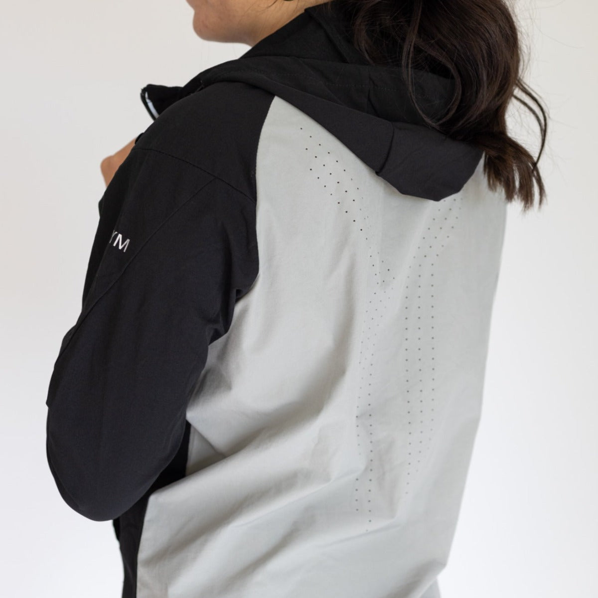 Back view of the Women's Hiking Jacket by DYM Athletics, highlighting the breathable design and stylish color blocking for outdoor activities.
