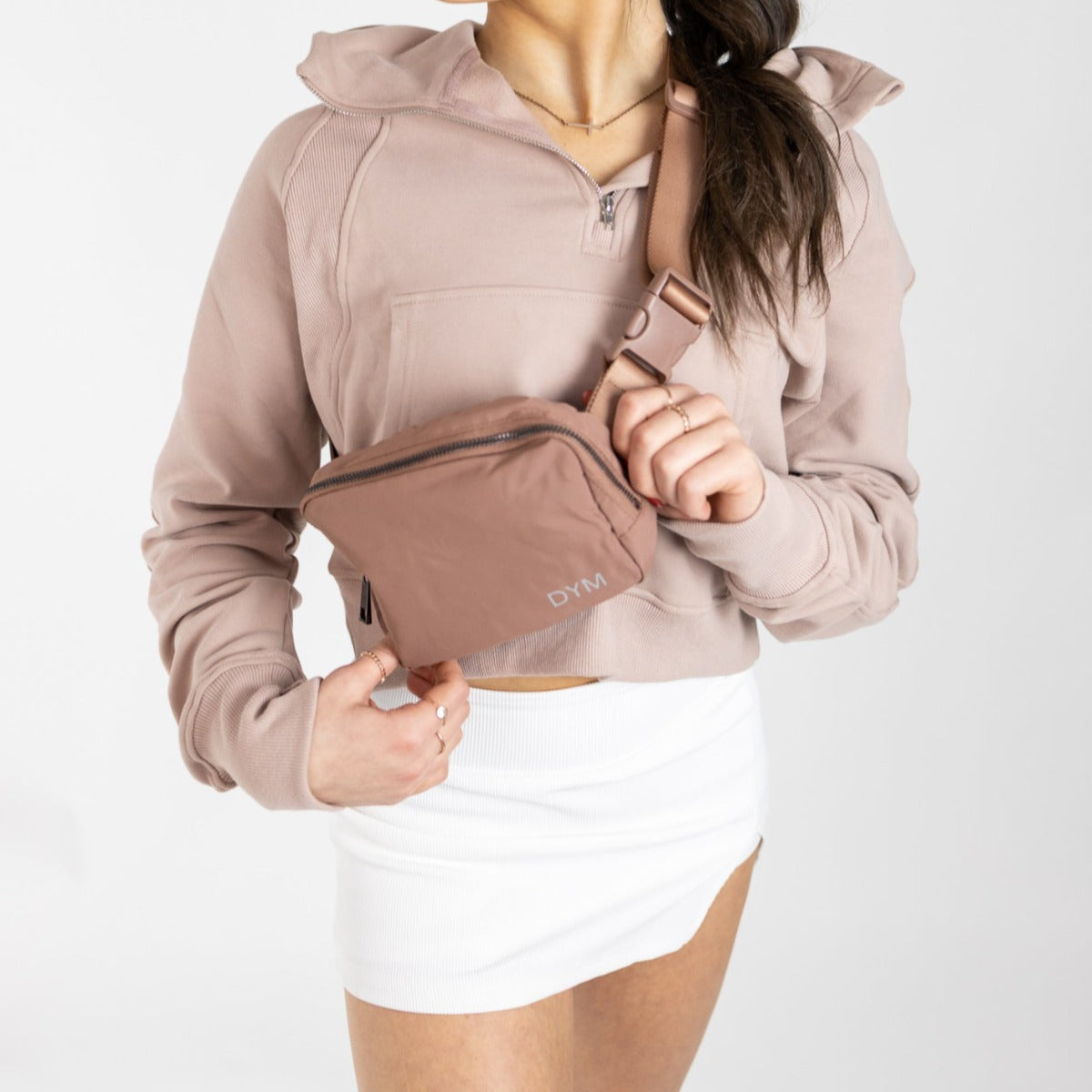 Model wearing The Score Skirt by DYM Athletics, showcasing a stylish A-line silhouette paired with a casual hoodie and a trendy bag. Perfect for golf, tennis, or casual outings.