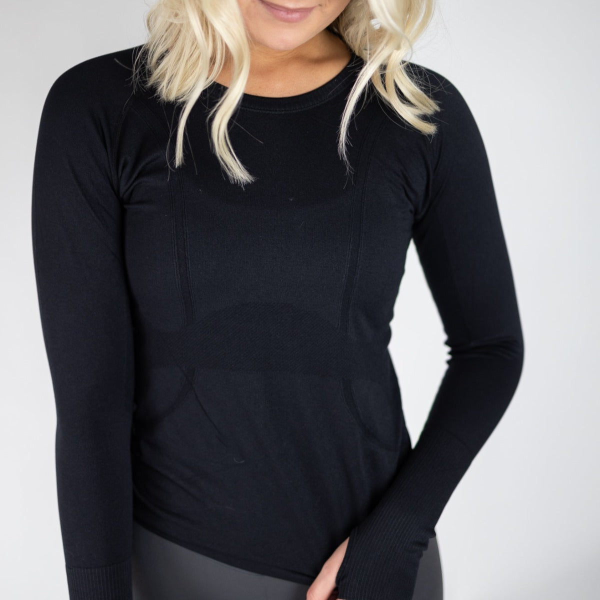DYM Athletics Trainer Lightweight Long Sleeve in black worn by a model, showcasing its stylish design and flattering fit.
