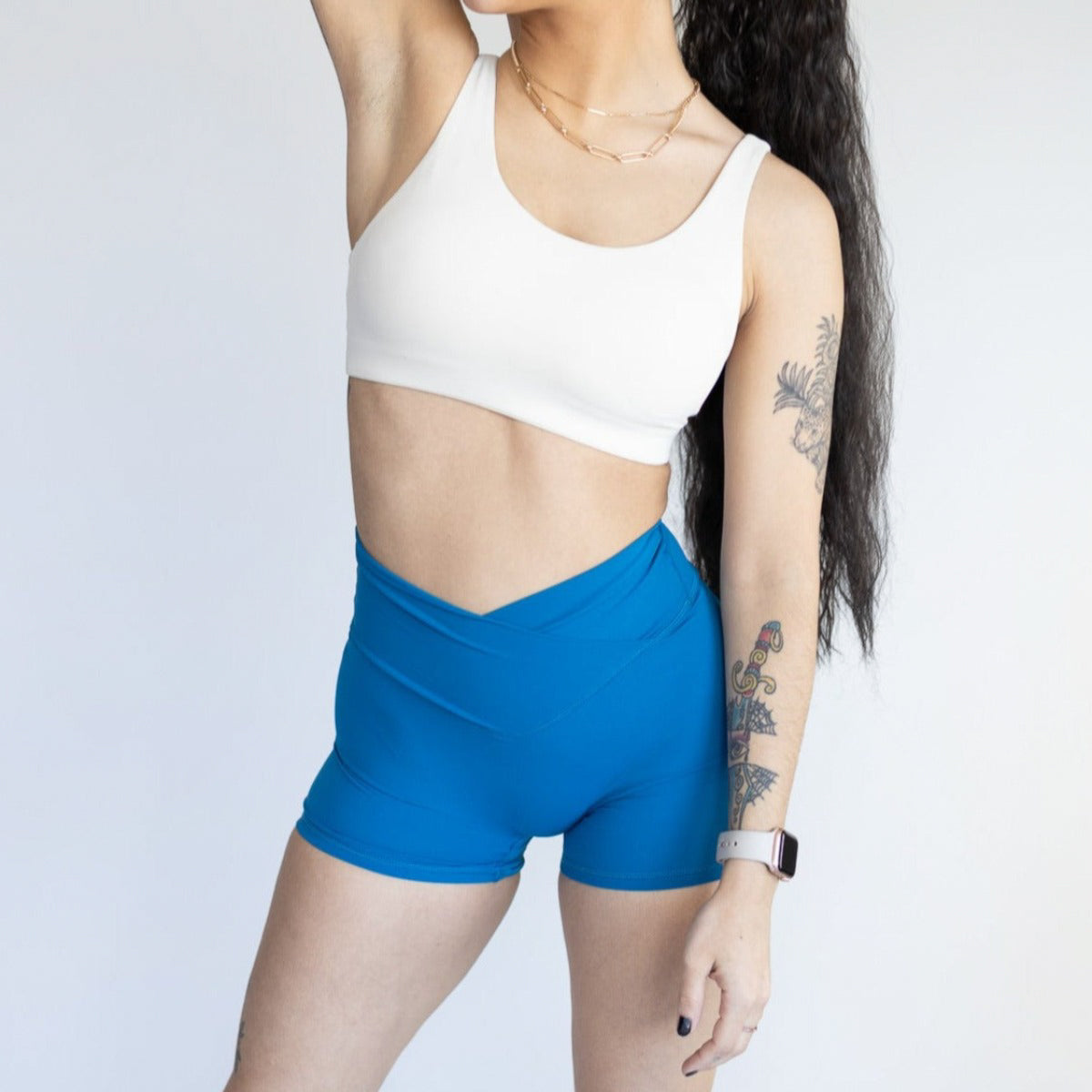 Model wearing DYM Athletics Flex & Flow 4" V-Waist Shorts in blue, featuring a flattering fit and buttery soft fabric, perfect for workouts and casual outings.