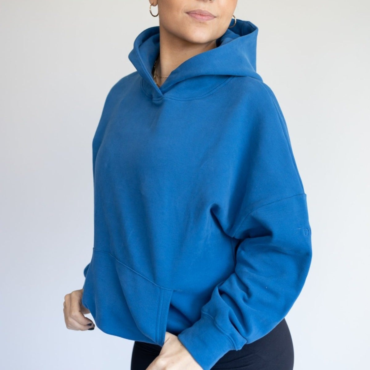 Close-up of a model wearing the blue Cozy Up Boyfriend Hoodie by DYM Athletics, highlighting the relaxed design and cozy fabric.