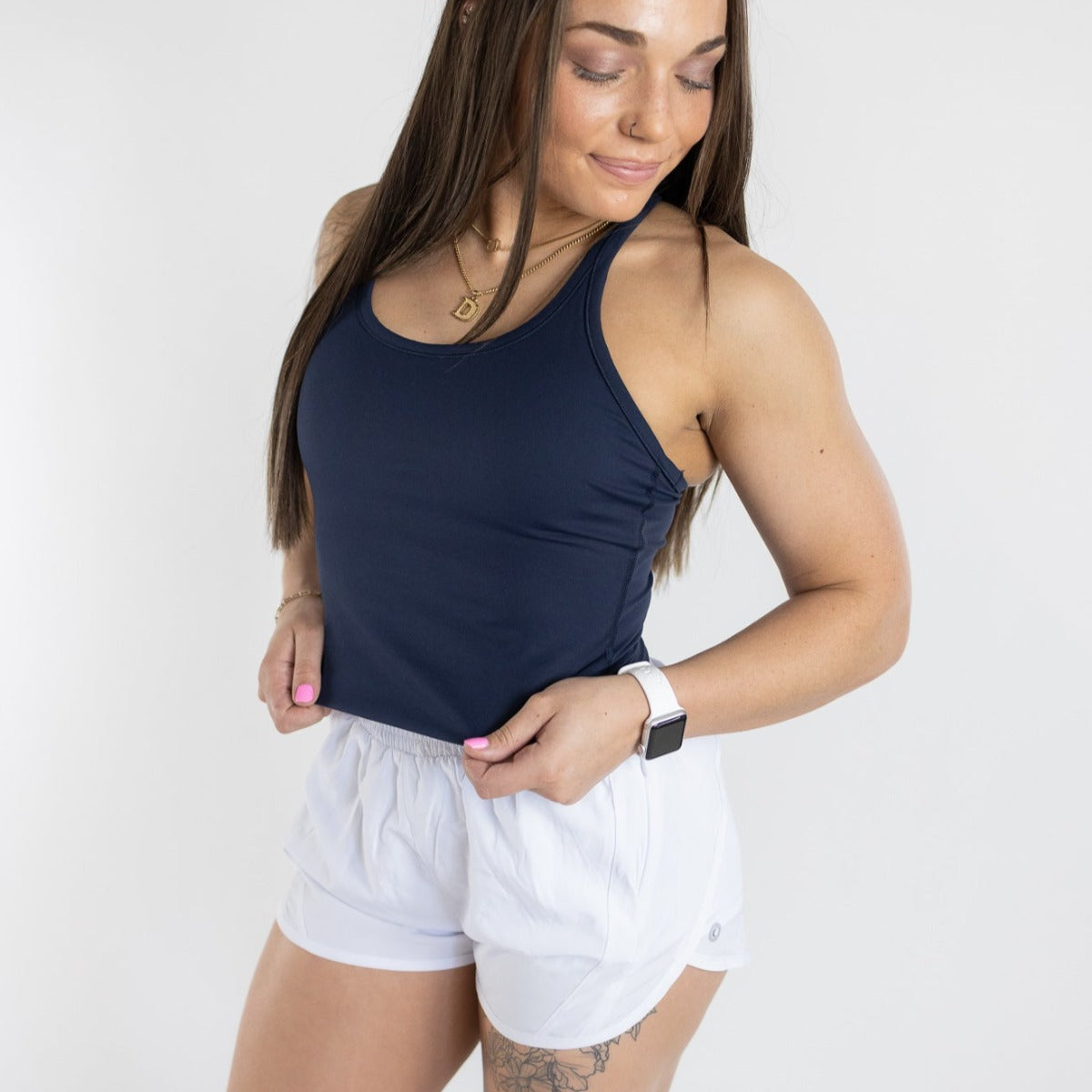 Woman in the Energy Full Length Everyday Tank by DYM Athletics, paired with white shorts. Ideal for sporty and casual looks.