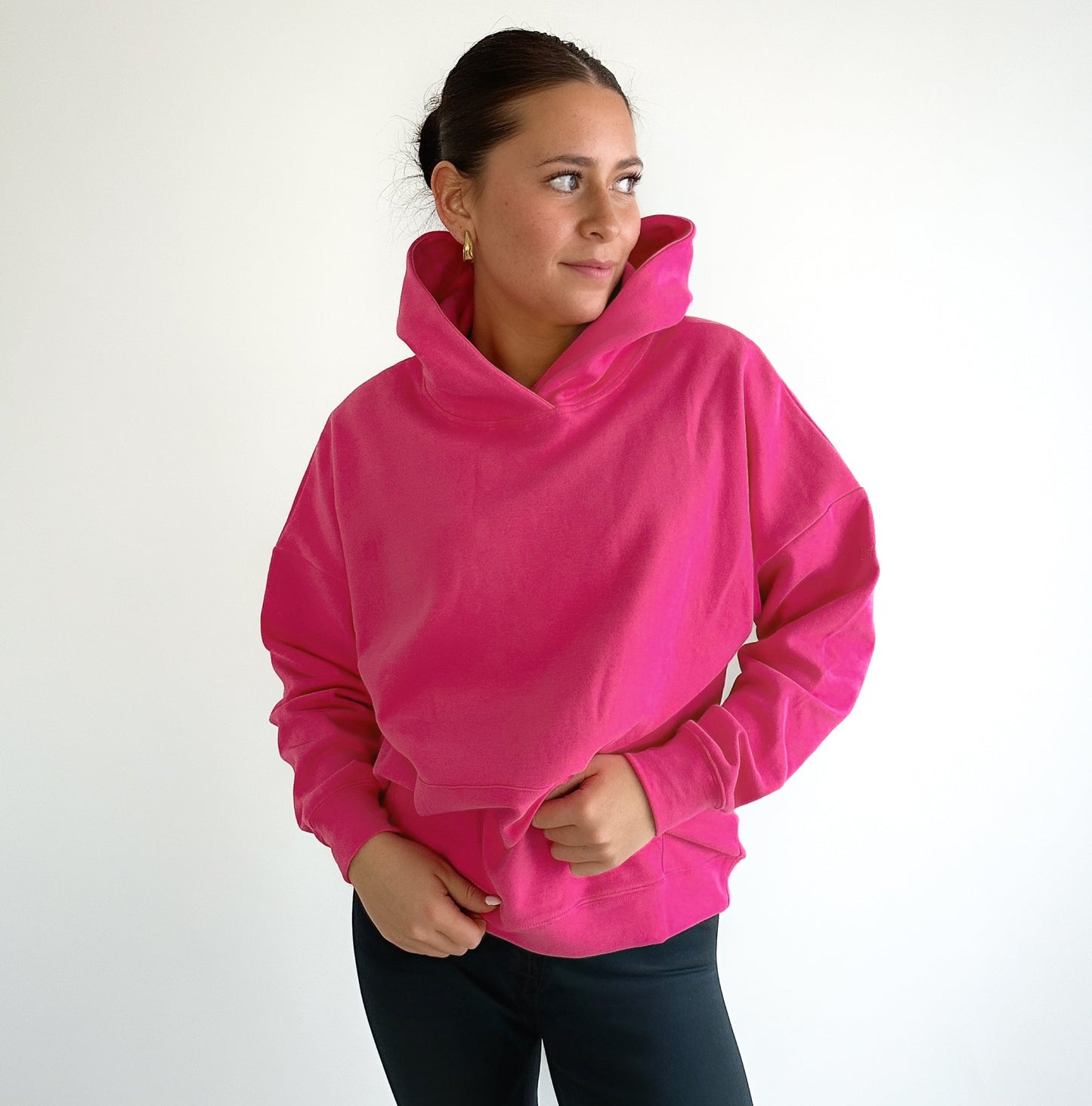 Model posing in the Cozy Up Boyfriend Hoodie in vibrant pink from DYM Athletics, highlighting its stylish design and comfortable fit.