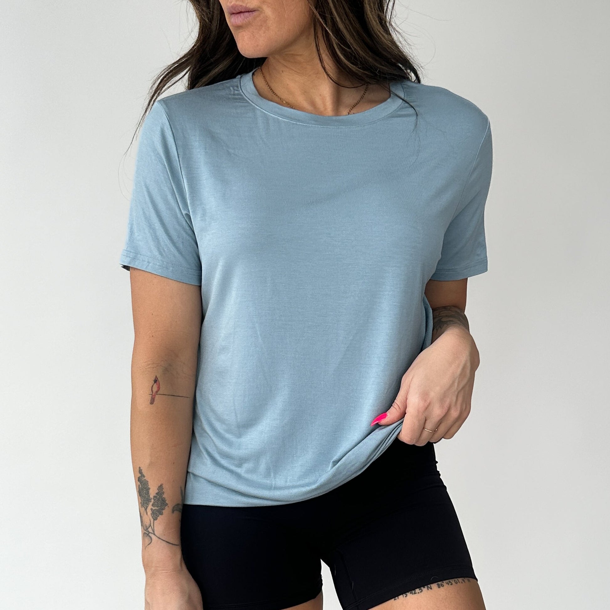 Female model sporting a light blue Breathe Bamboo T-Shirt by DYM Athletics, perfect for any casual occasion.
