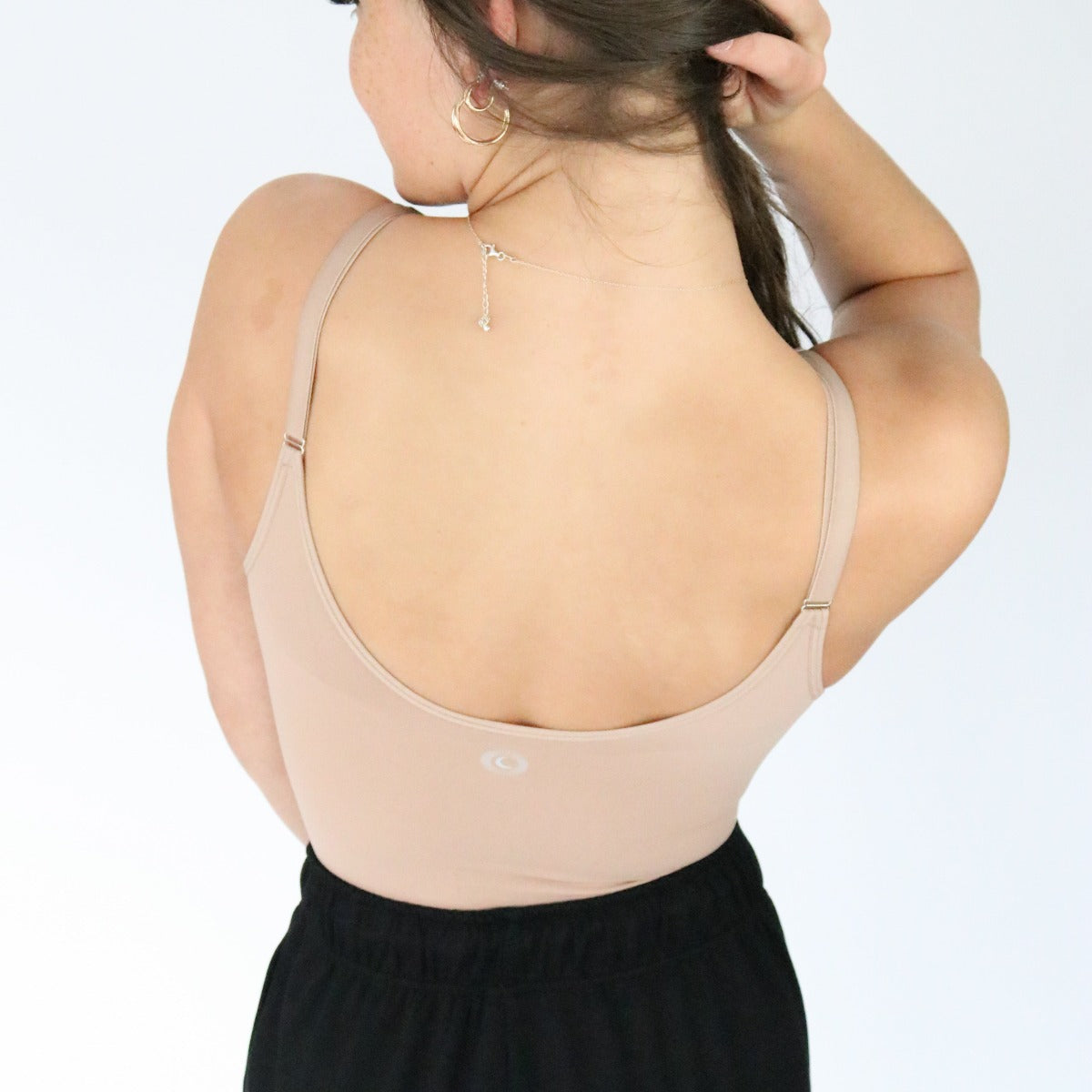 Back view of the DYM Athletics Sculpting Comfort Bodysuit in beige, highlighting the sleek design and comfortable straps.