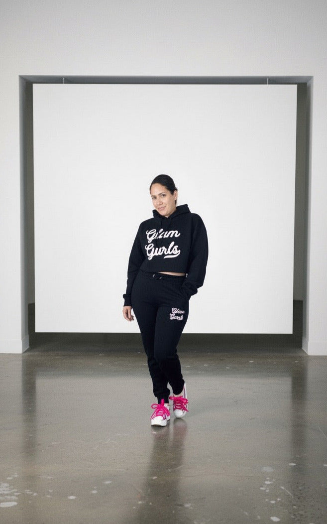 Model wearing Customized Glam Gurls Cropped Hoodie with Puff Print in black, paired with matching joggers, showcasing a stylish and comfy look by Glam Gurls.