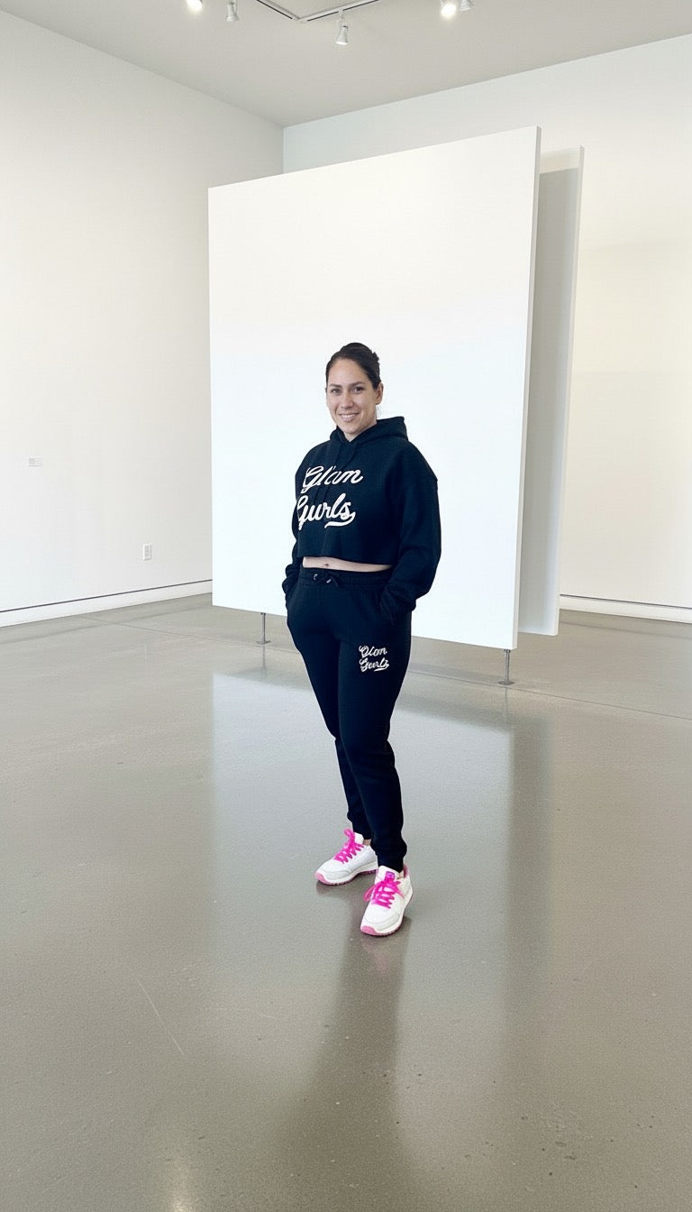 Model standing confidently in the Customized Glam Gurls Cropped Hoodie with Puff Print in black, displaying a fashionable outfit with matching joggers by Glam Gurls.