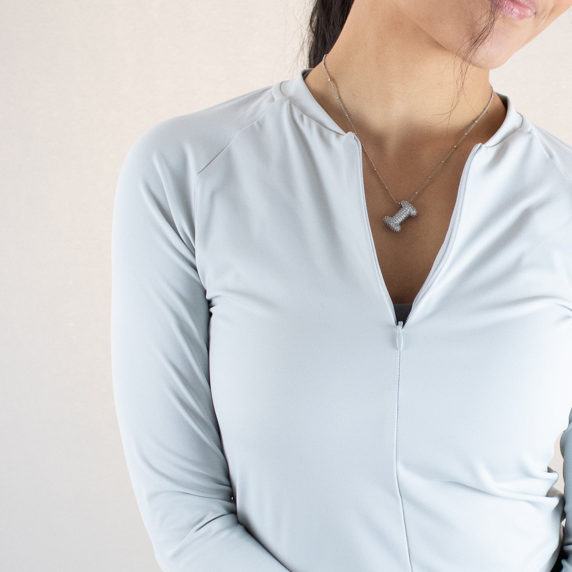 Close-up of a woman showcasing the DYM Athletics Elite 1/4 Zip Long Sleeve, emphasizing its tailored fit and stylish neckline.