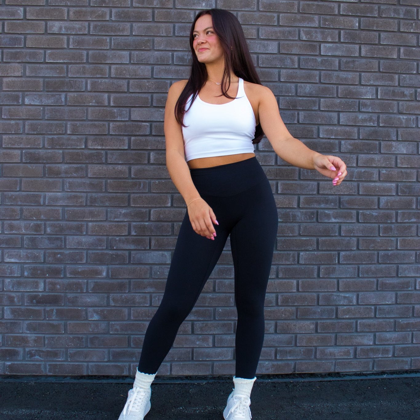 Woman modeling DYM Athletics Buttery Soft Seamless Leggings for Ultimate Comfort and Support in black color. The leggings showcase a high waist design and smooth seamless construction, perfect for workouts and everyday wear.