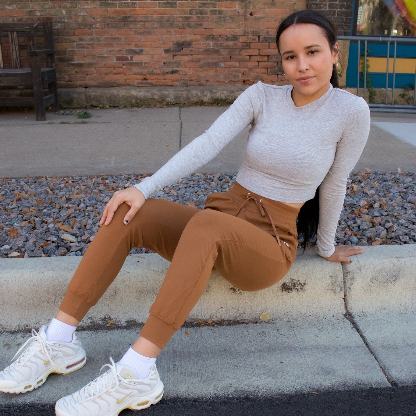 Female model wearing Performance Pro Lightweight Active Jogger by DYM Athletics, sitting casually, showcasing a stylish outfit.