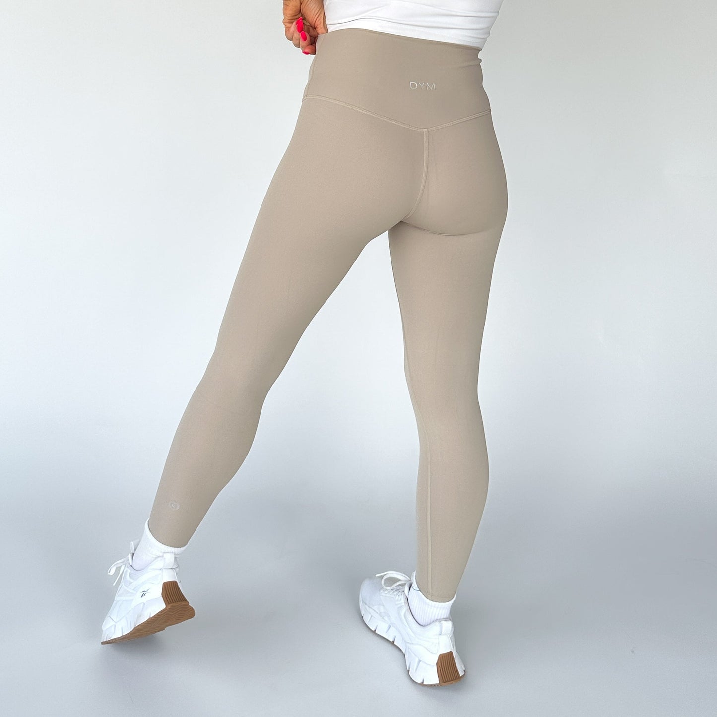 Back view of DYM Athletics Buttery Soft Seamless Leggings in light beige, illustrating the supportive fit and seamless design tailored for ultimate comfort.