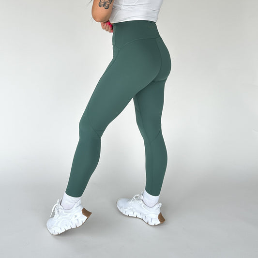 Side view of a model wearing DYM Athletics Trainer Muscle Tone Legging in green, showcasing the high-waist design and sculpted fit.