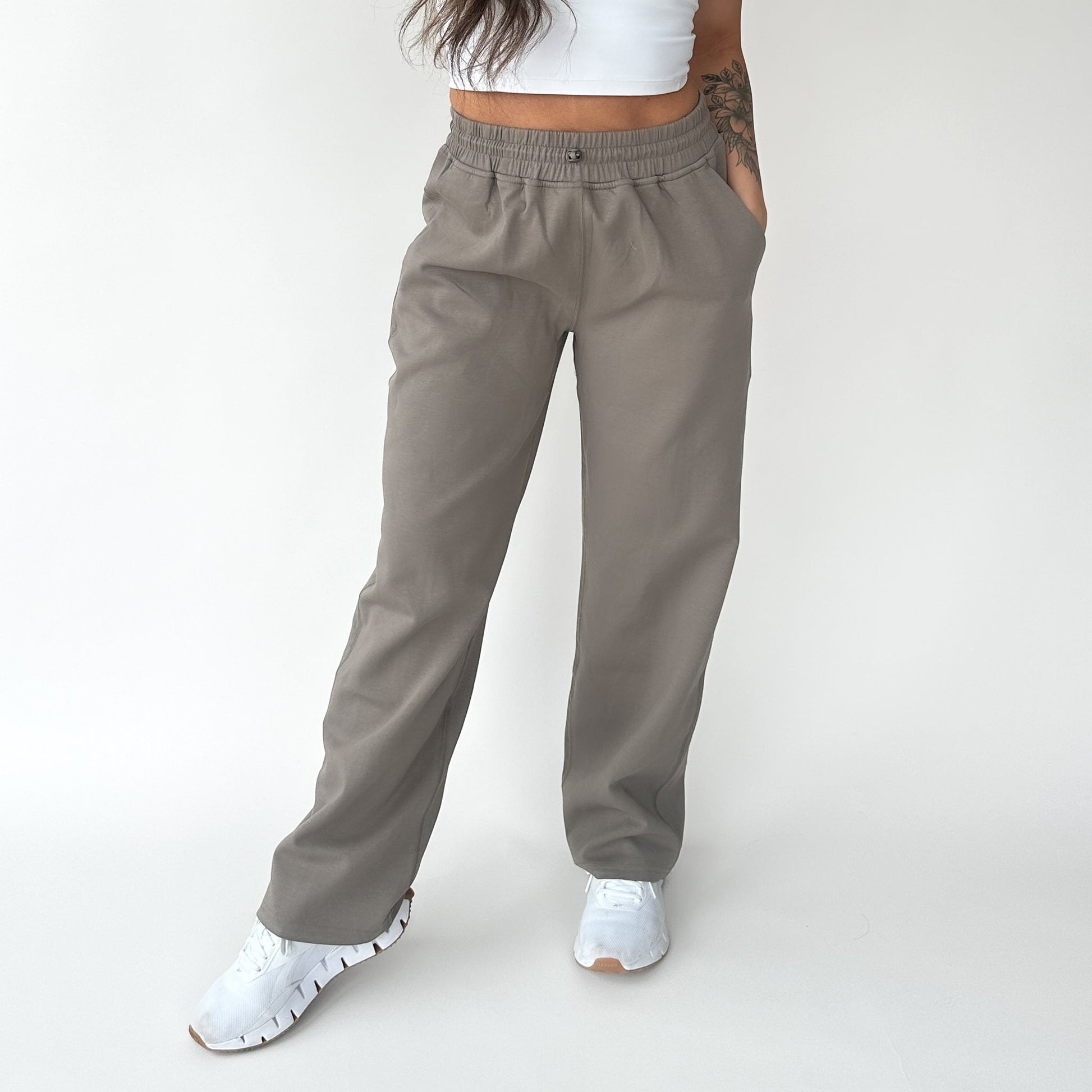 Woman wearing Relax Wide Leg Sweatpant with Cinch Drawstring by DYM Athletics in a cozy beige color, showcasing a casual and relaxed fit.