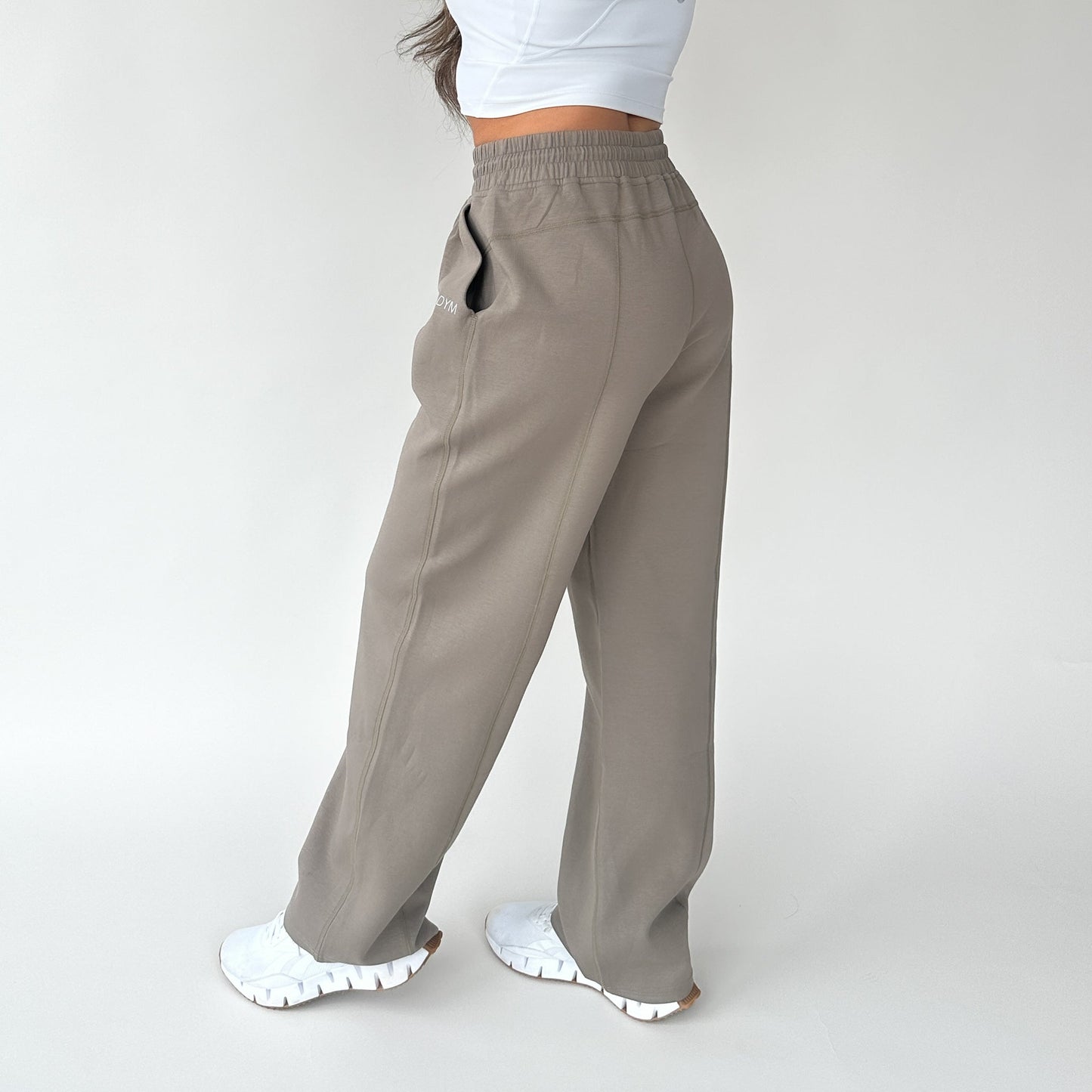 Side view of a woman in Relax Wide Leg Sweatpants with Cinch Drawstring by DYM Athletics, emphasizing a relaxed silhouette and stylish design.