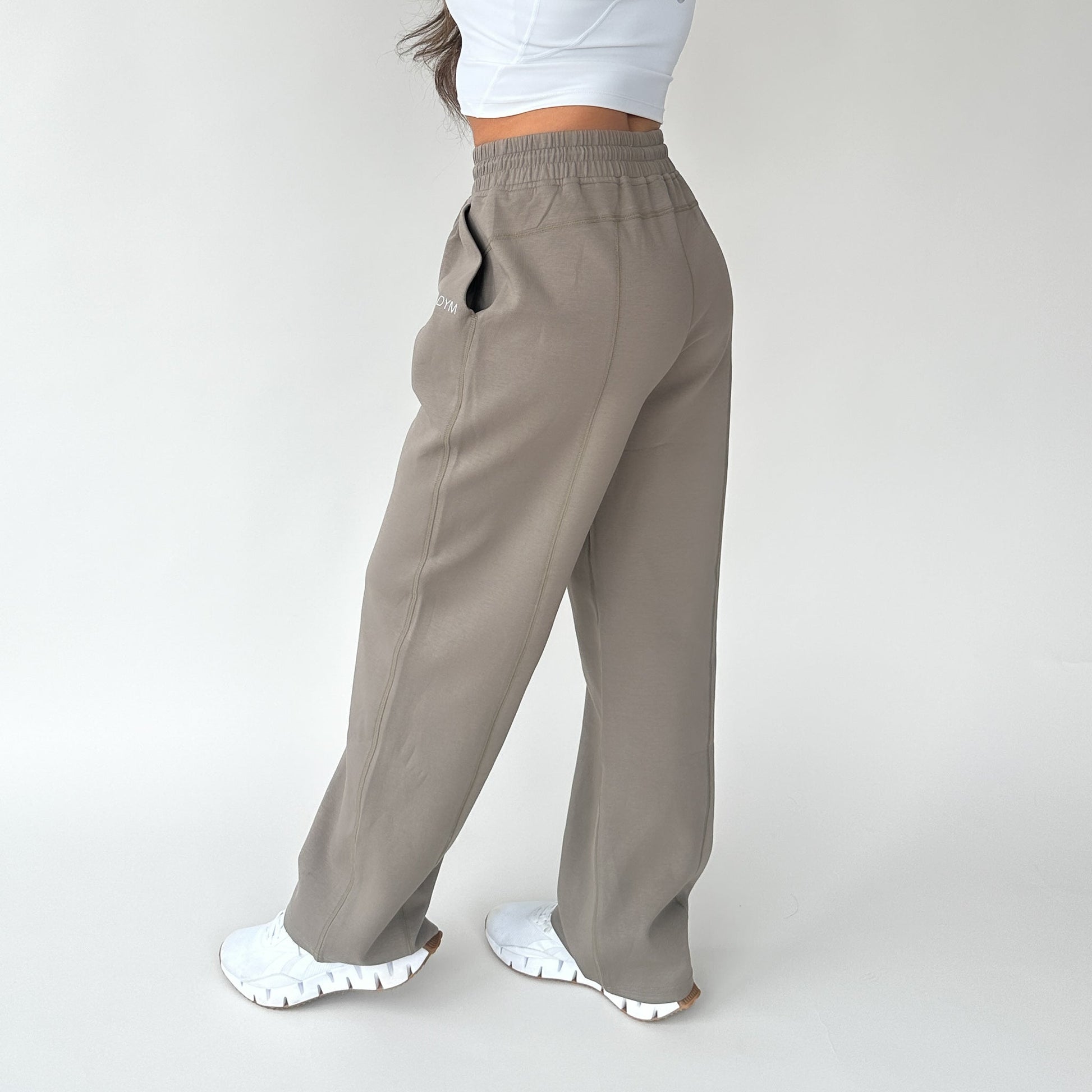 Side view of a woman in Relax Wide Leg Sweatpants with Cinch Drawstring by DYM Athletics, emphasizing a relaxed silhouette and stylish design.