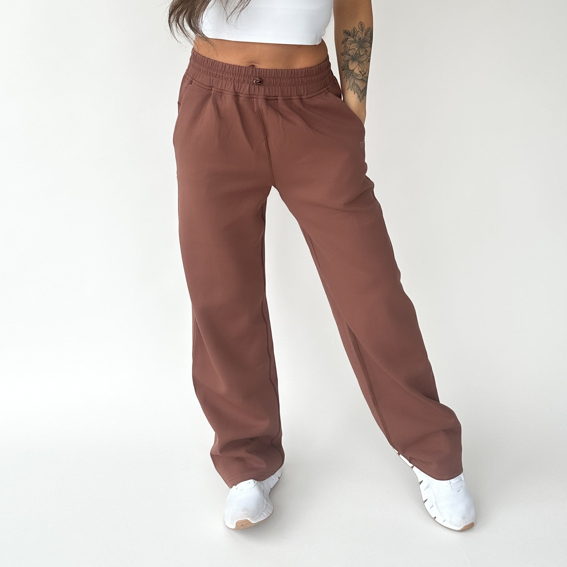 A woman standing in Relax Wide Leg Sweatpants with Cinch Drawstring by DYM Athletics, styled in a cozy and relaxed look.