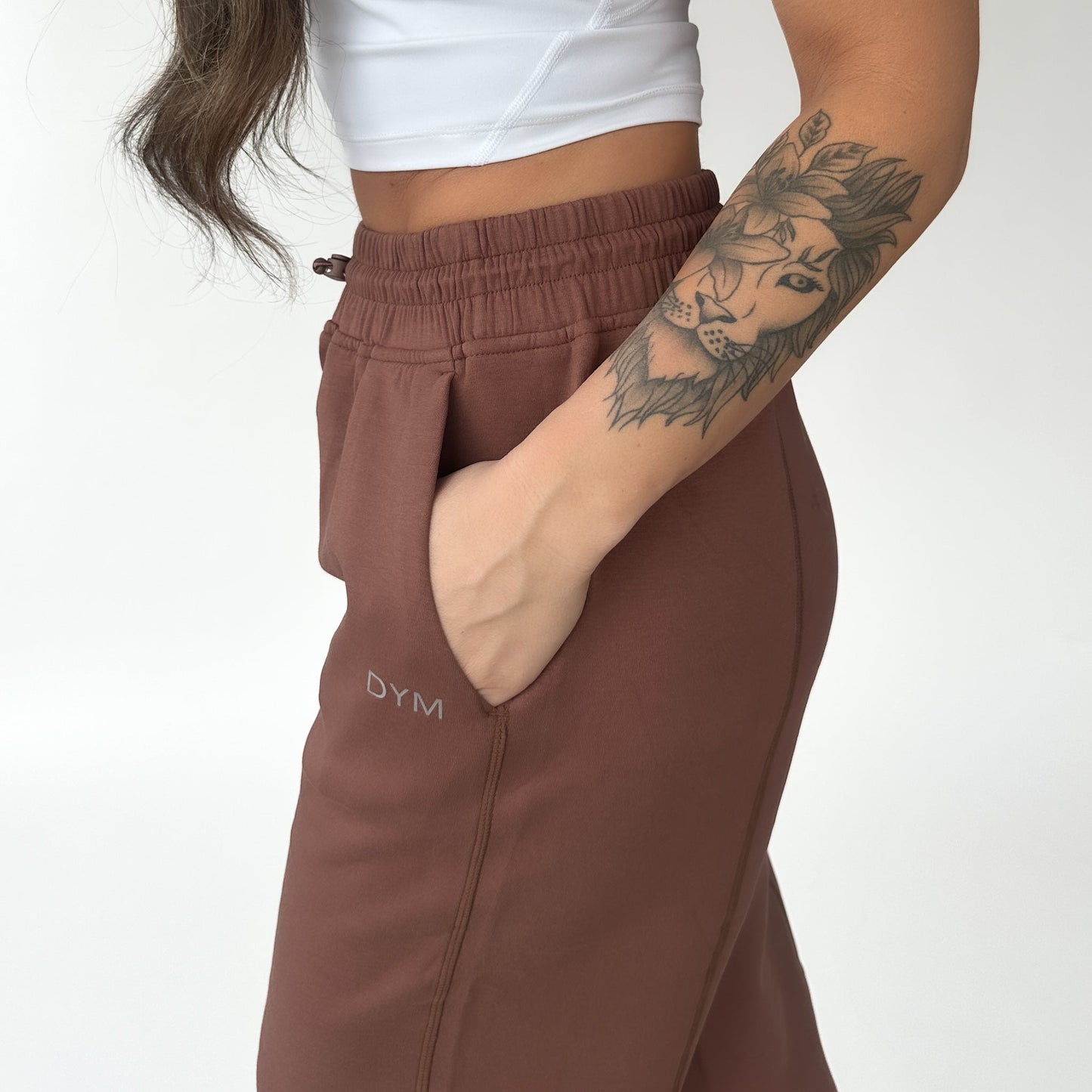 Close-up view of a woman's hand in a Relax Wide Leg Sweatpant with Cinch Drawstring by DYM Athletics, showcasing pockets and a stylish design.
