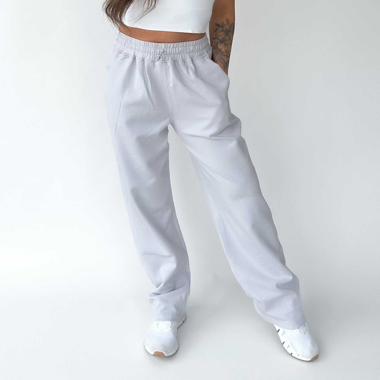 A woman striking a casual pose in Relax Wide Leg Sweatpants with Cinch Drawstring by DYM Athletics, showcasing the loose fit.