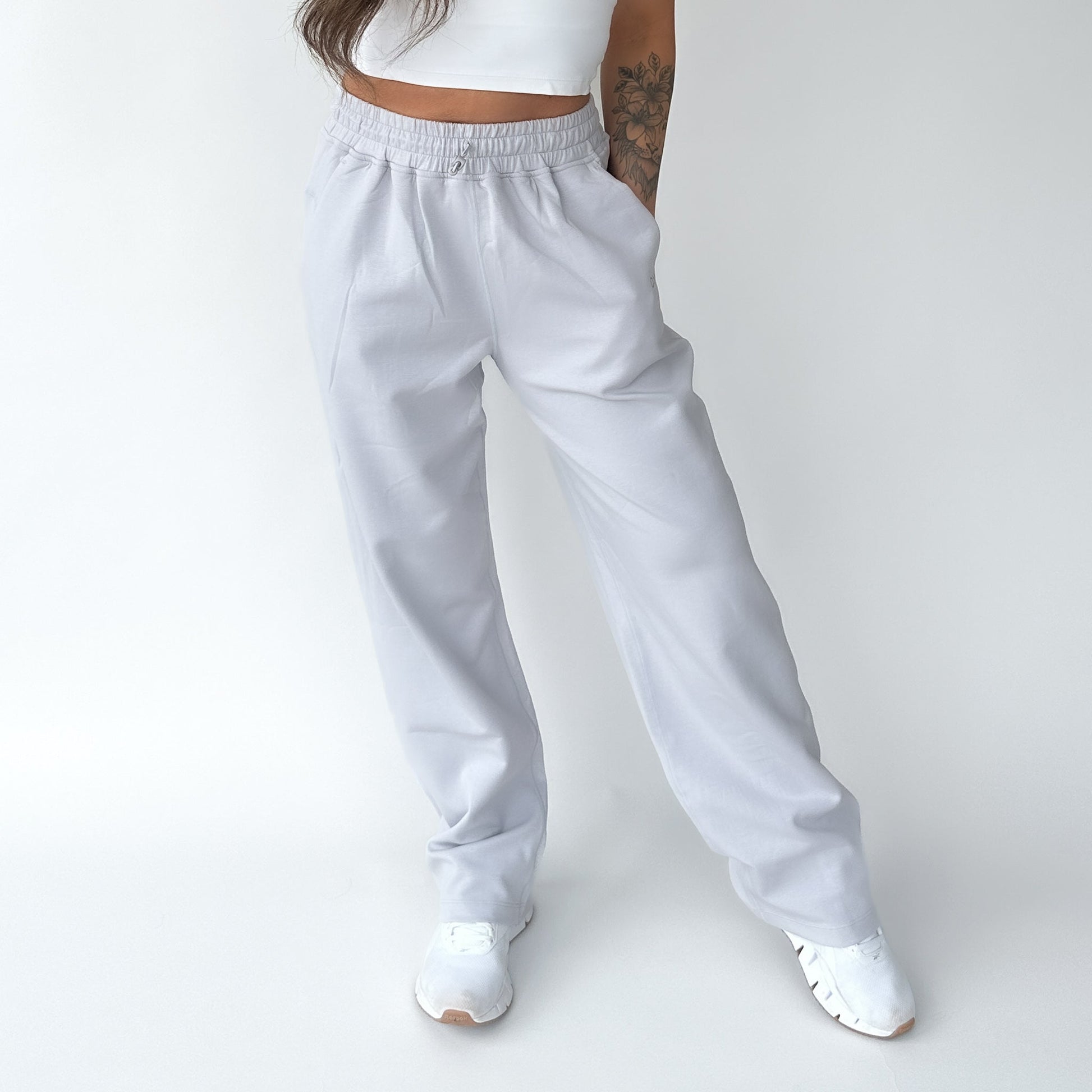 A woman striking a casual pose in Relax Wide Leg Sweatpants with Cinch Drawstring by DYM Athletics, showcasing the loose fit.