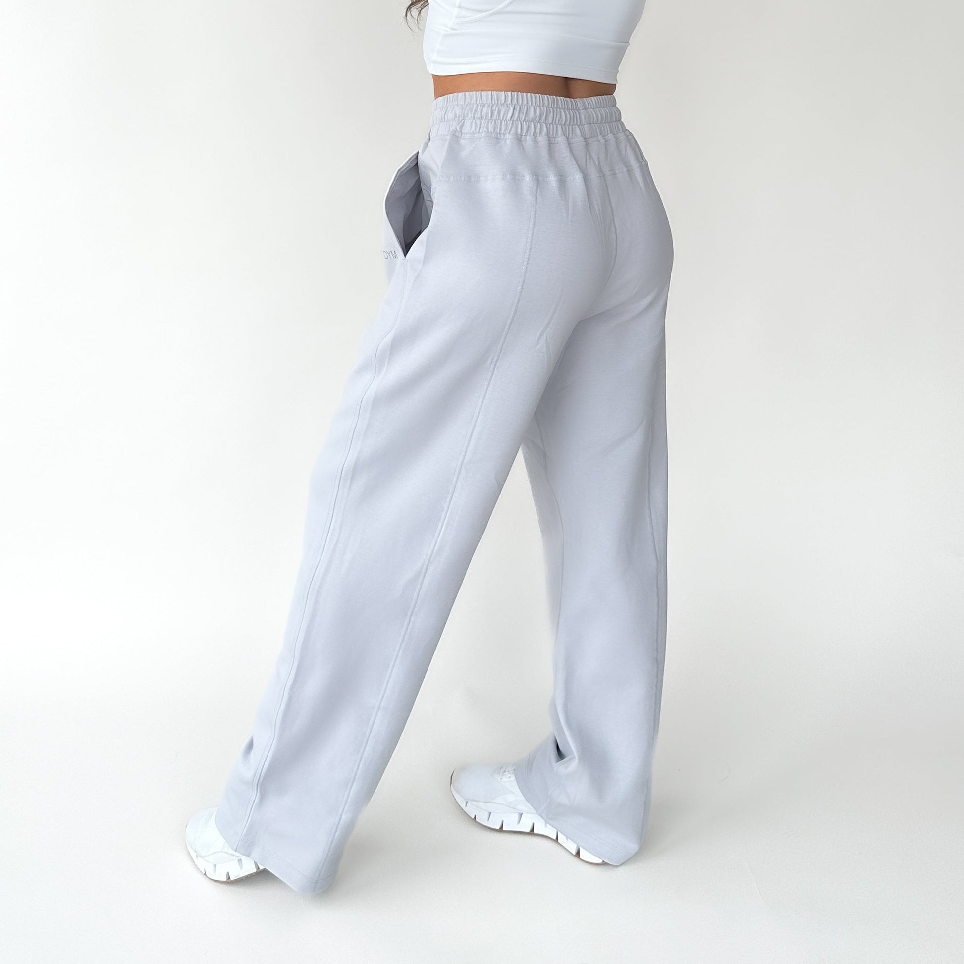Back view of a woman wearing Relax Wide Leg Sweatpants with Cinch Drawstring by DYM Athletics, highlighting the comfortable fit.