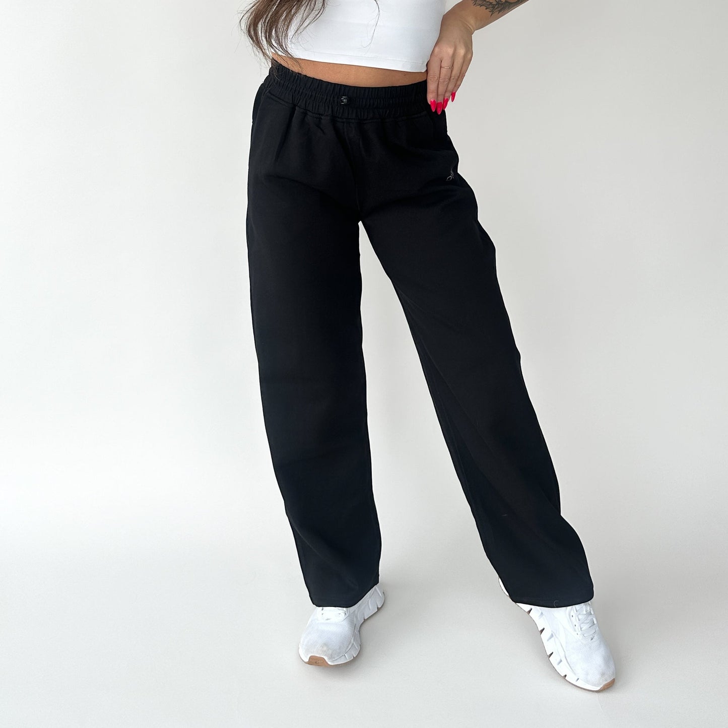Front view of a woman styling the Relax Wide Leg Sweatpant with Cinch Drawstring by DYM Athletics in black, emphasizing comfort and fashion.