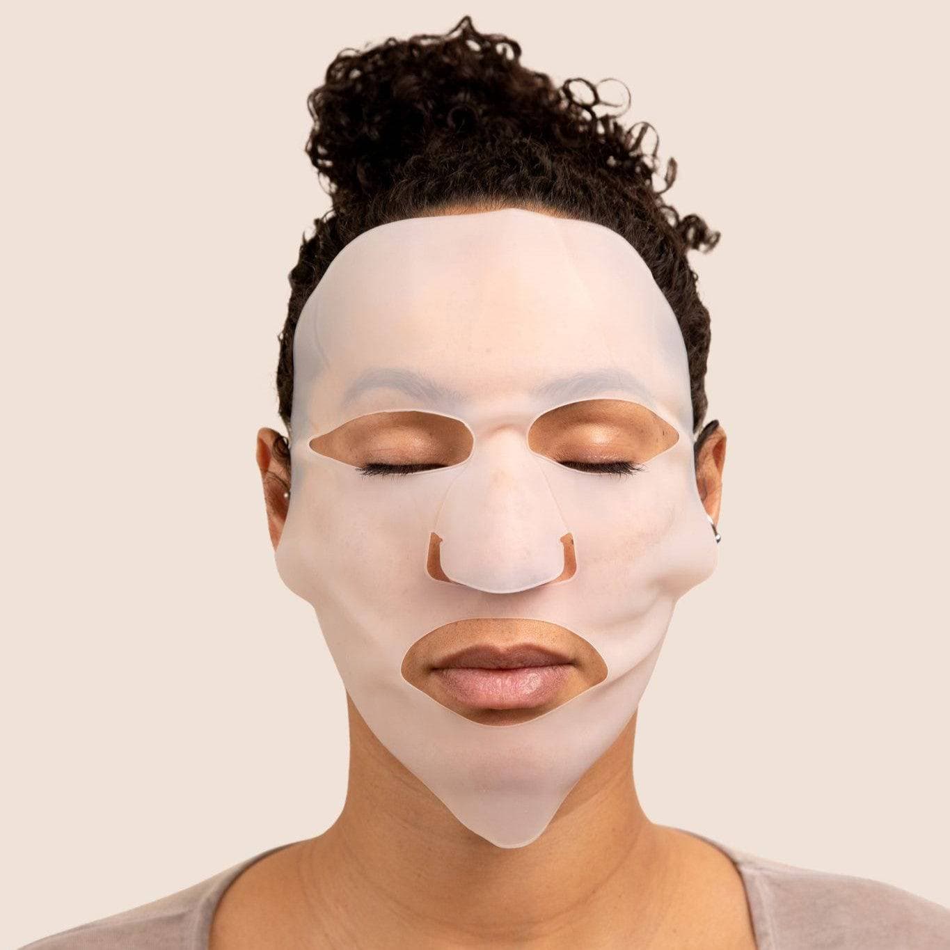 Relaxing woman wearing a silicone hydro mask from the Hydrating Duo by Cosmedica Skincare, promoting hydration and rejuvenation.