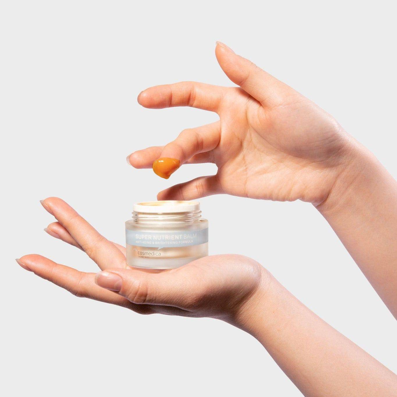 Cosmedica Skincare Super Nutrient Facial Balm surrounded by natural ingredients like rosehip and green tea, highlighting its nutrient-rich formula