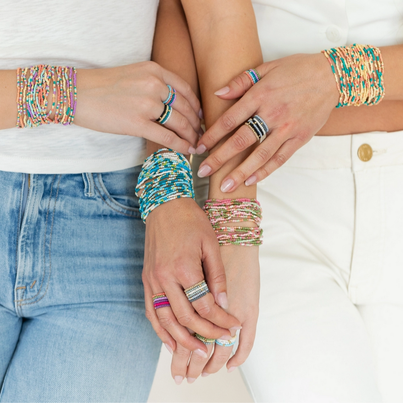 Stylish women showcasing handcrafted stretch seed bead bracelet sets from Splendid Iris, featuring vibrant colors and unique designs.