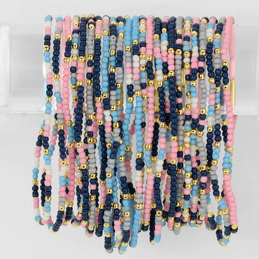 Close-up of colorful stretch seed bead bracelets displayed on a clear stand by Splendid Iris, perfect for adding flair to any outfit.