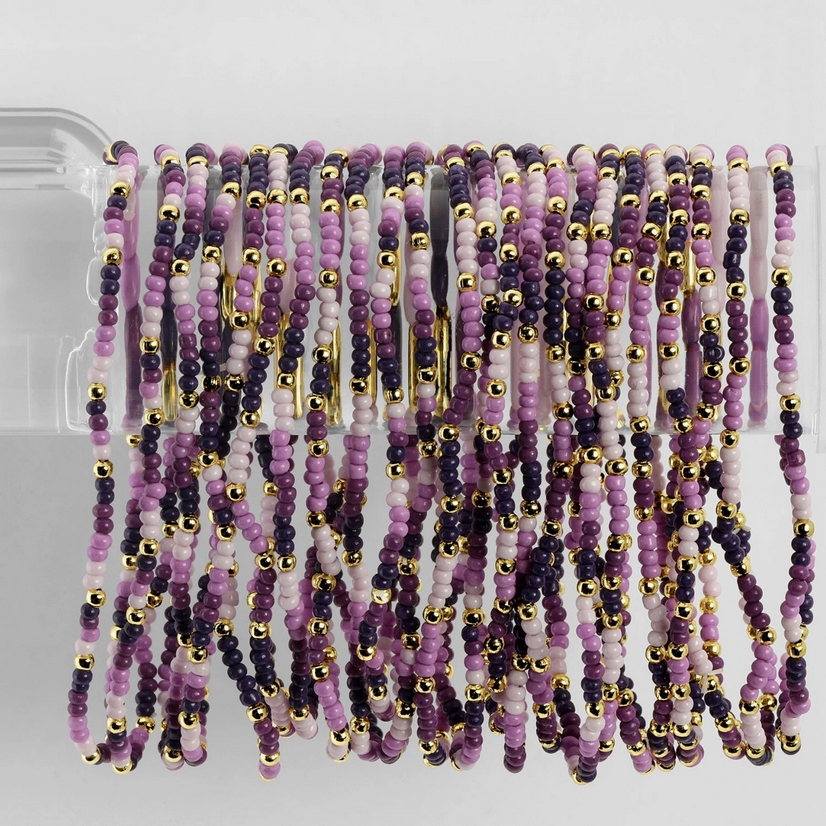 Beautiful assortment of purple and gold stretch seed bead bracelets by Splendid Iris, showcasing handcrafted quality and vibrant hues.