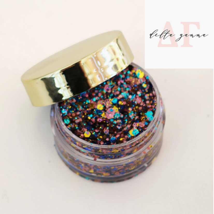 Go Greek Face Glitter Set by Stinaface featuring a vibrant mix of multicolored glitter in a clear jar with a shiny gold lid, perfect for adding sparkle to any occasion.