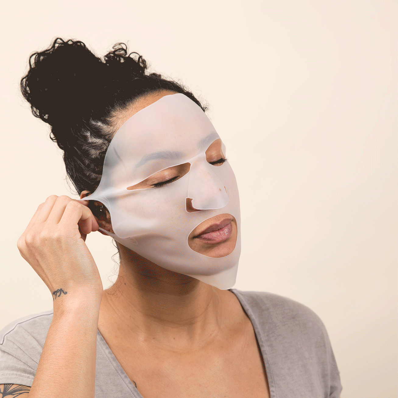 An individual gently peeling off the Reusable Silicone Hydro Mask by Cosmedica Skincare, showcasing its easy application and comfortable fit.