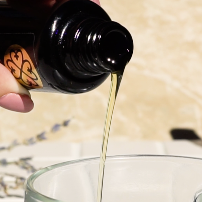 Applying True Moringa Oil for Glowing Skin, Hair & Body Care on a hand showing its smooth texture and rich nutrients.